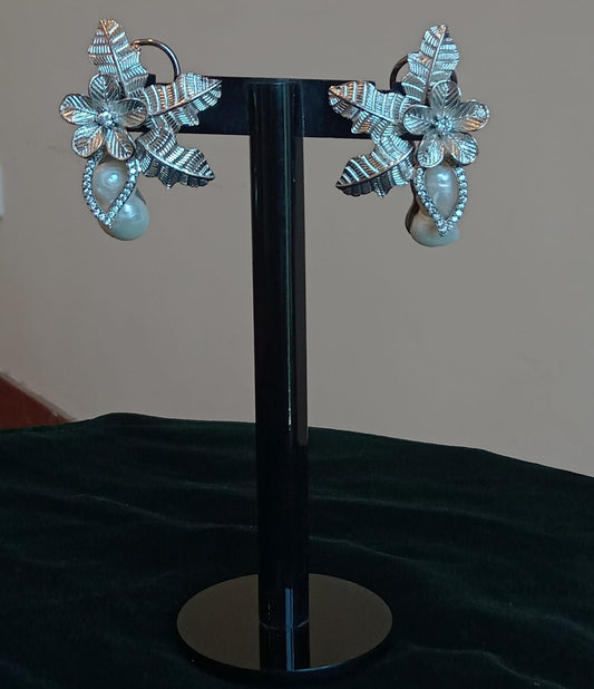 Silver flower with pearls.